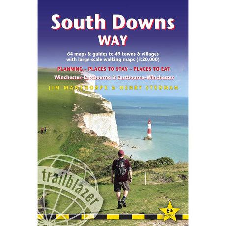 Front cover of the Trailblazer 'South Downs Way' guidebook, featuring a scenic photograph of a hiker on a grassy cliffside overlooking the English Channel with white chalk cliffs and a red-and-white lighthouse. The cover has a blue-to-purple gradient header with white and red title text.