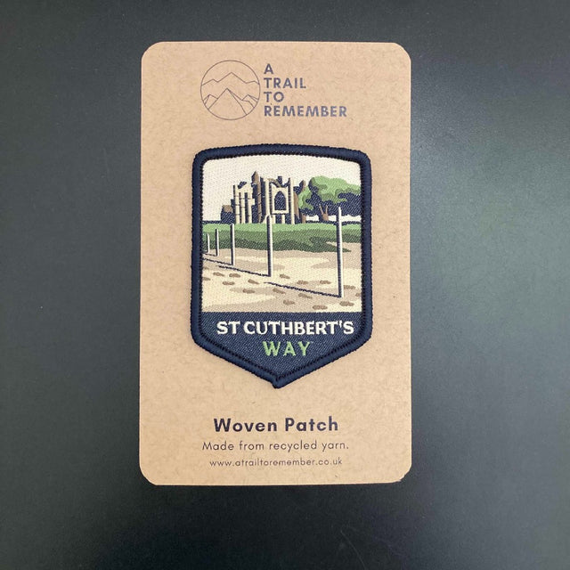 Woven patch for St Cuthbert's Way on a cardboard backing with branding.
