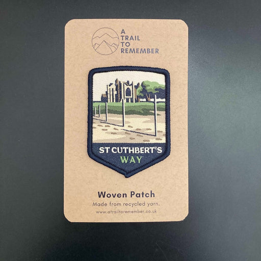 Woven patch for St Cuthbert's Way on a cardboard backing with branding.