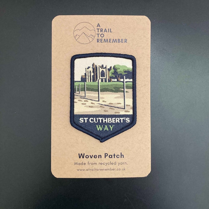 Woven patch for St Cuthbert's Way on a cardboard backing with branding.
