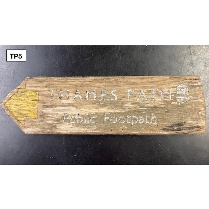 Wooden sign with 'Thames Path Public Footpath' engraving on a dark background