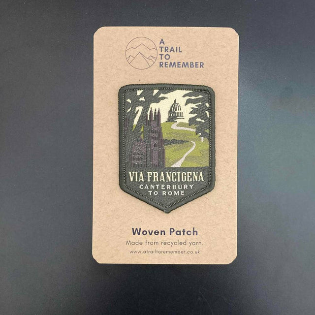 Woven patch on a cardboard backing with 'Via Francigena' design and branding.